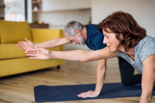 White man and woman practicing yoga pose indoors