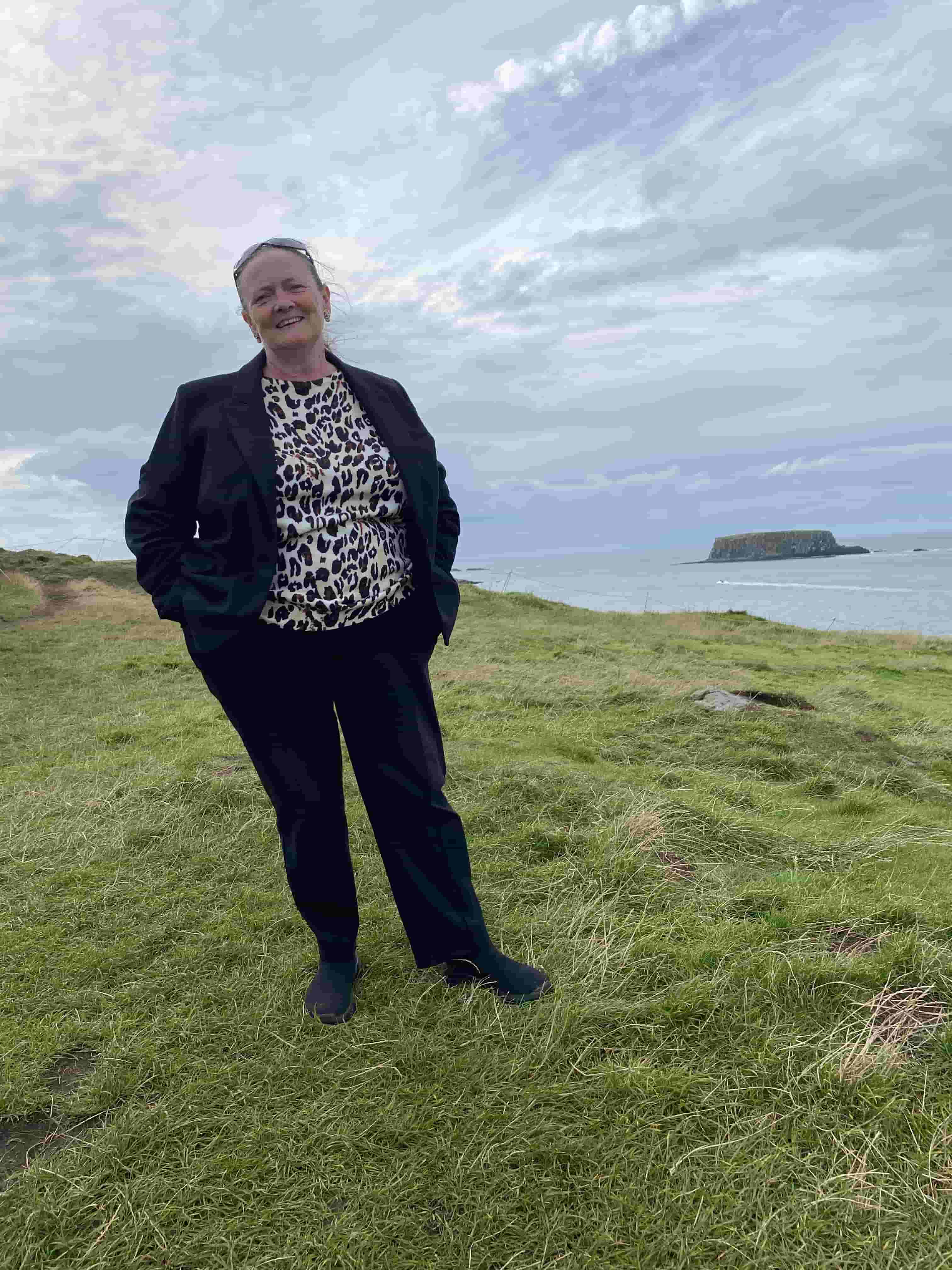 Suzanne outside in the countryside by the coast