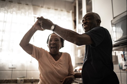 Smiling black couple dancing in kitchen