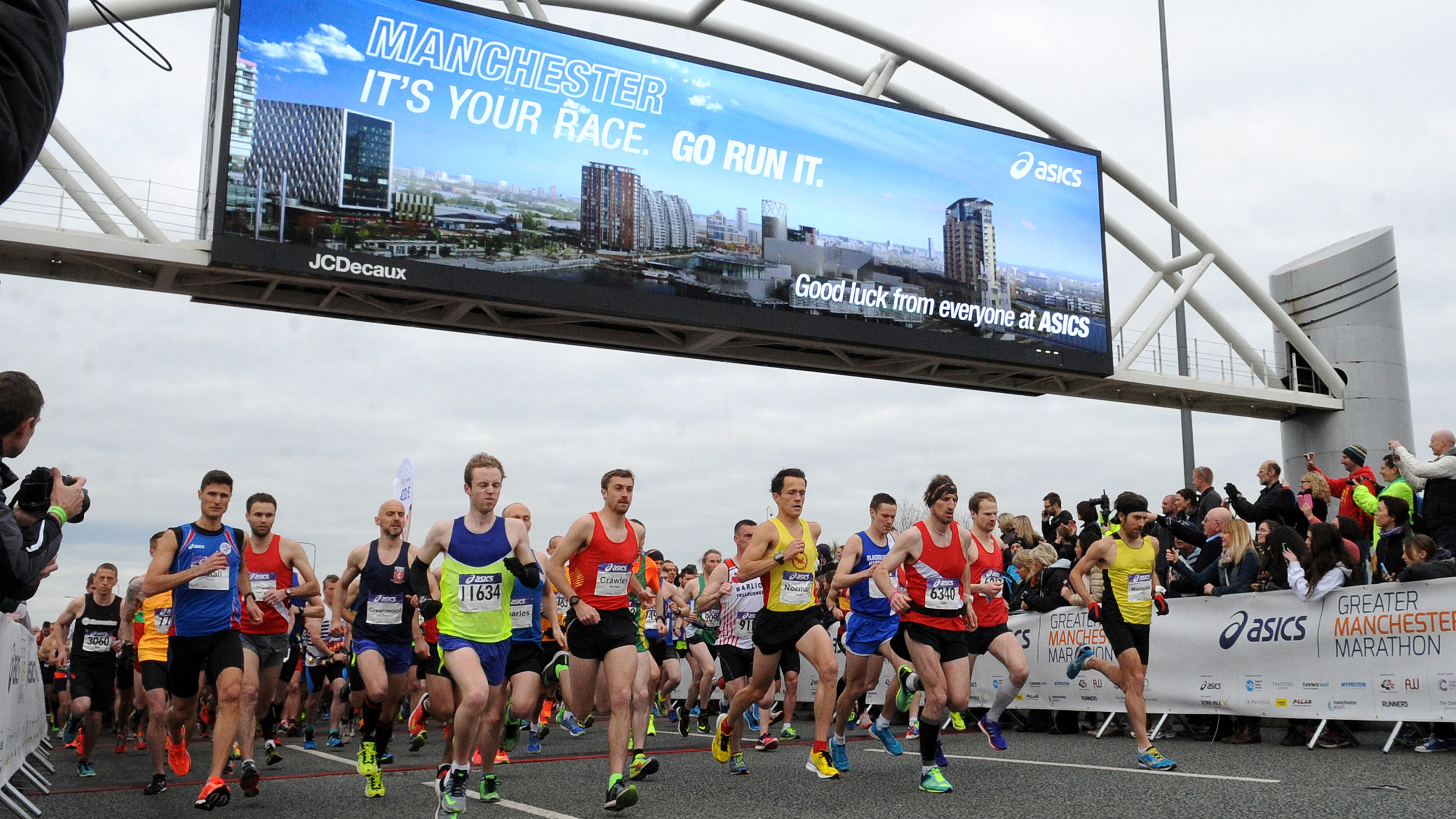 Runners on the course running under a bridge in Manchester