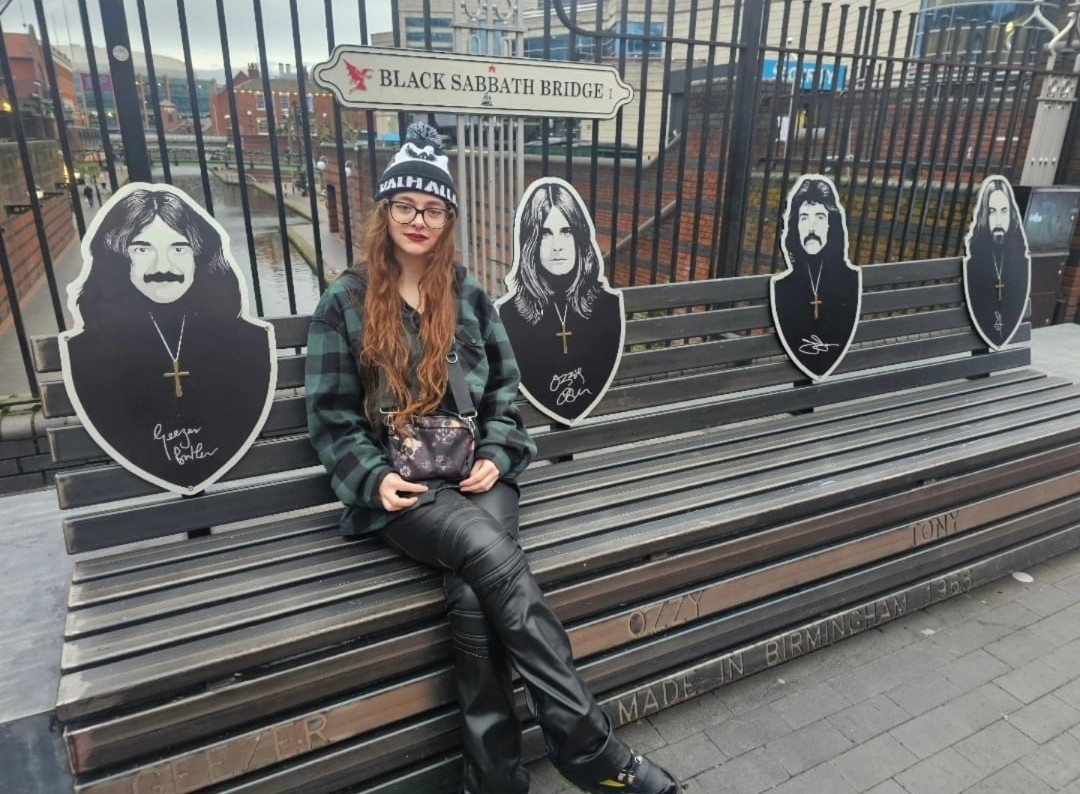 Amy sat on a bench on a bridge