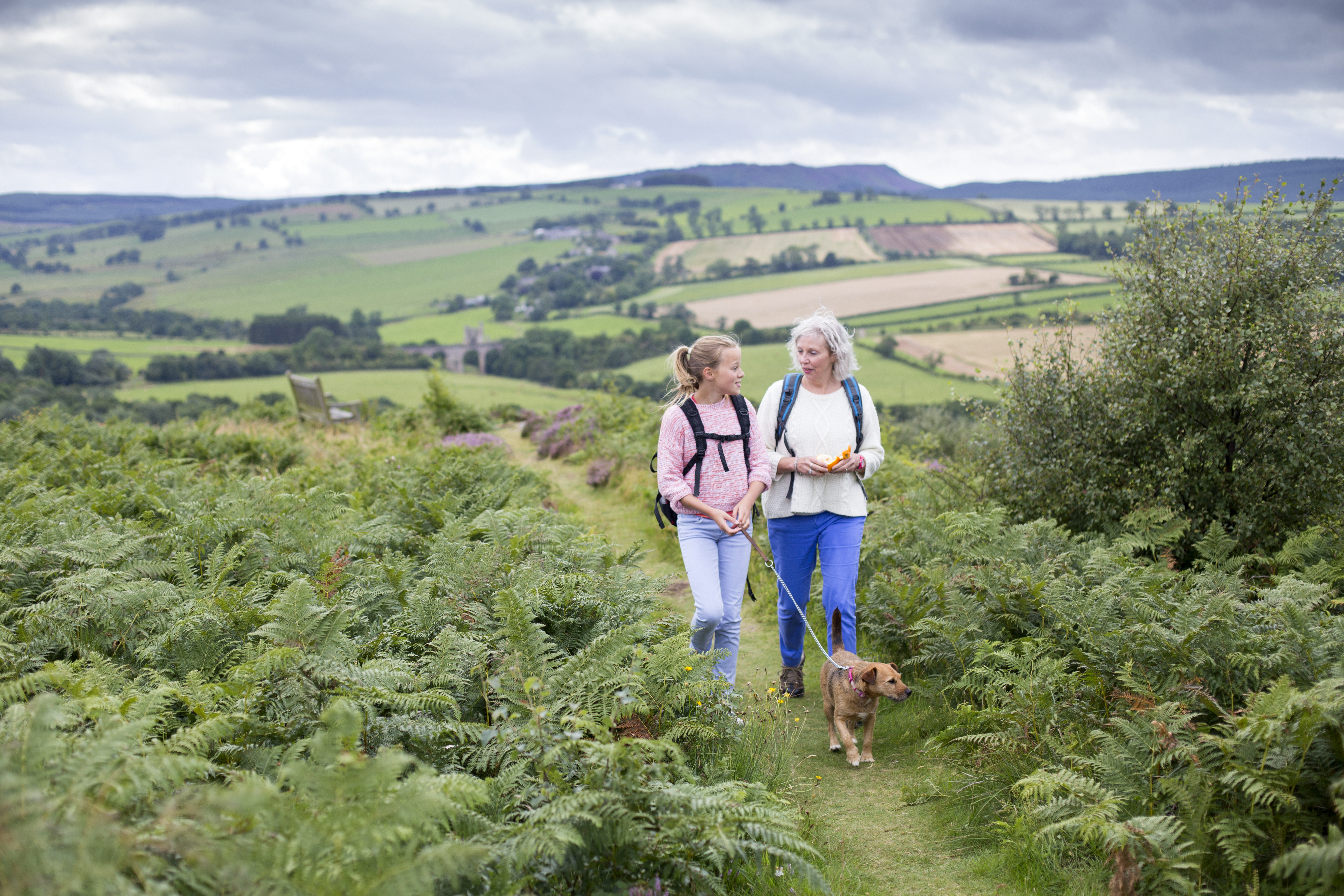 Two women walking on a trail in the British countryside