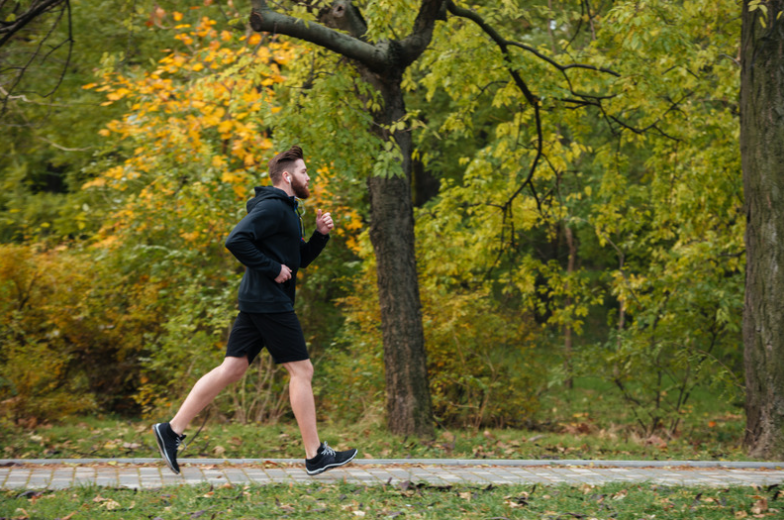 Runner in park surrounded by greenery