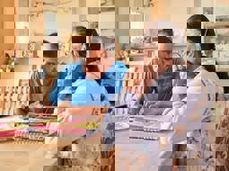 Hitesh sitting with his mum, doing paperwork